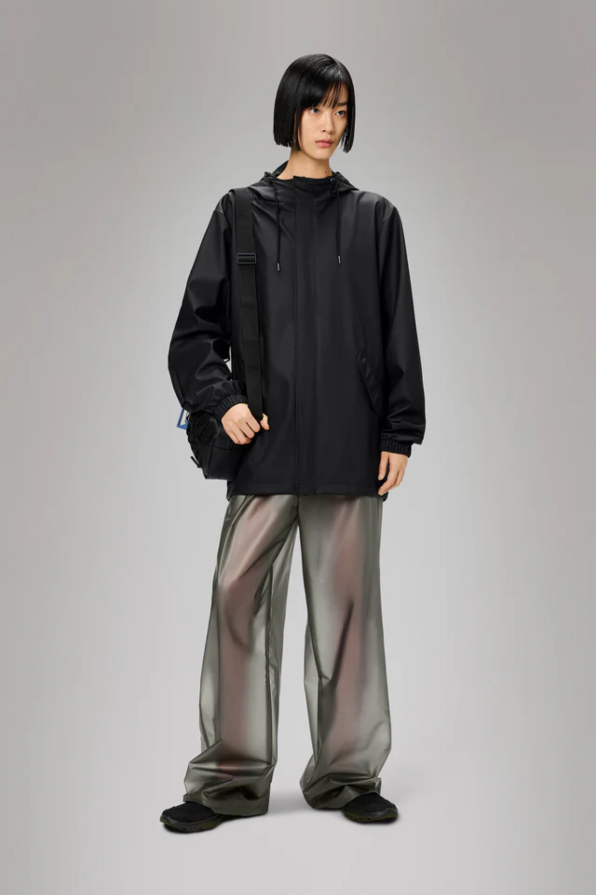 Model wearing the Rains fishtail jacket W3 in black. Front view