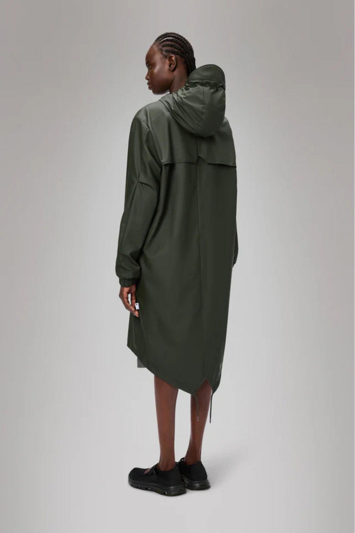 Model wearing the Rains fishtail parka W3 in green. Back view