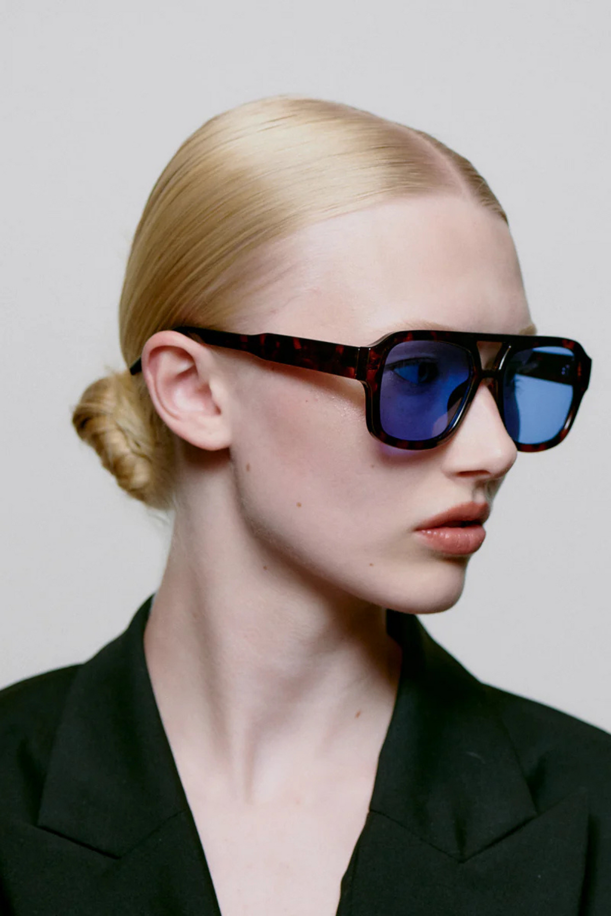 Model wearing the A. Kjaerbede kaya sunglasses in demi tortoise (blue lens). Side view