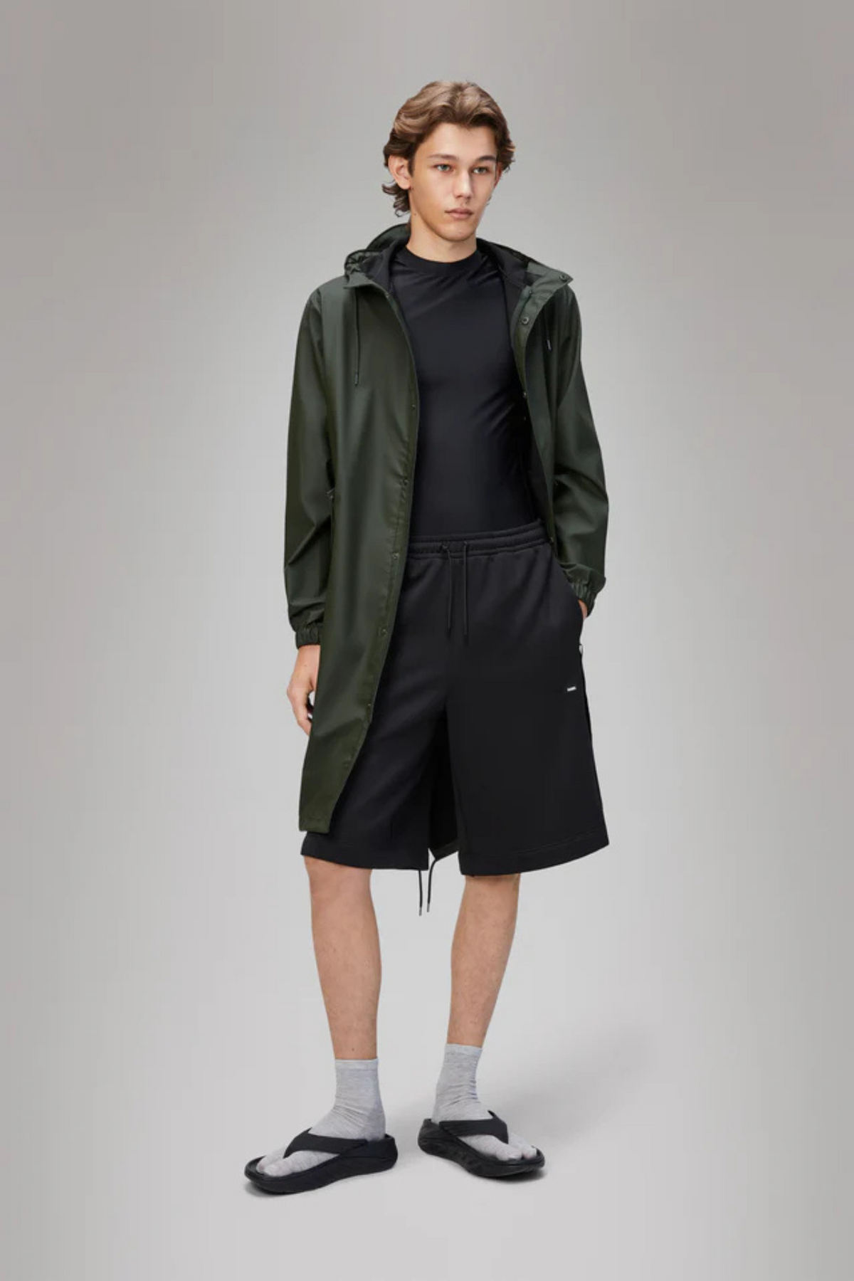 Model wearing the Rains fishtail parka W3 in green. Front view