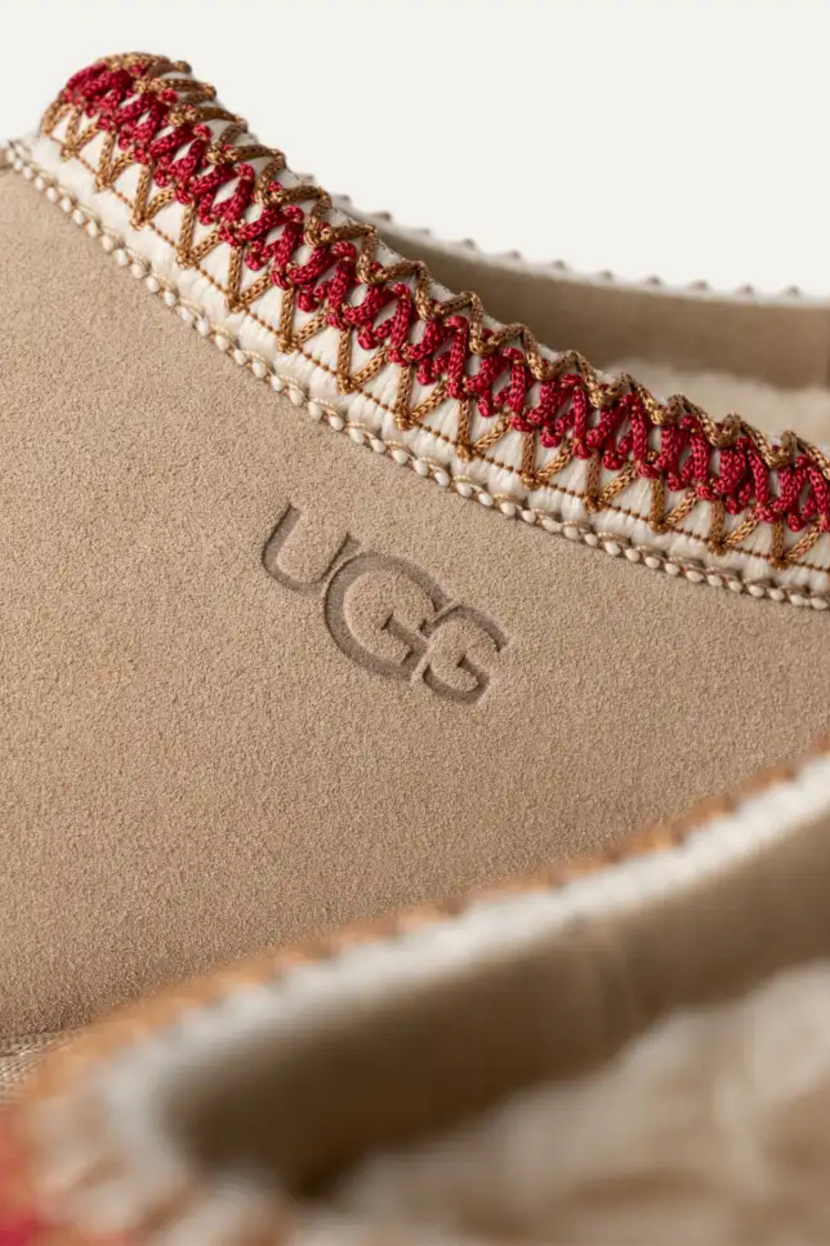 UGG women tasman in sand/dark cherry. Close logo view